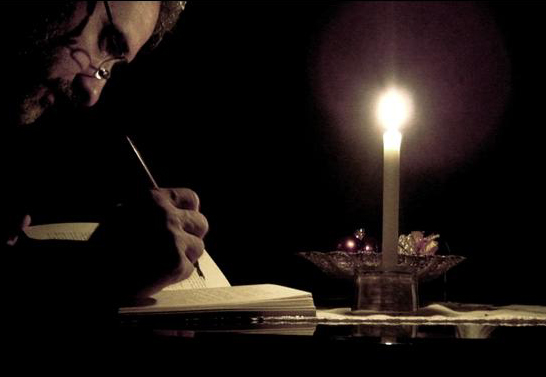 Man writing by candlelight
