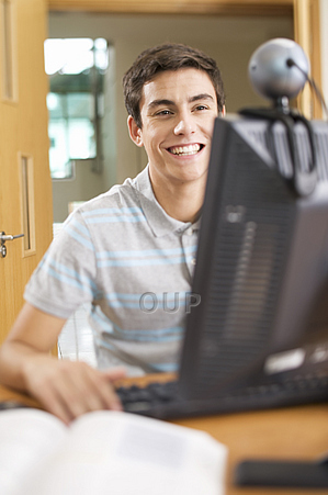 Young man working at a computer and smiling