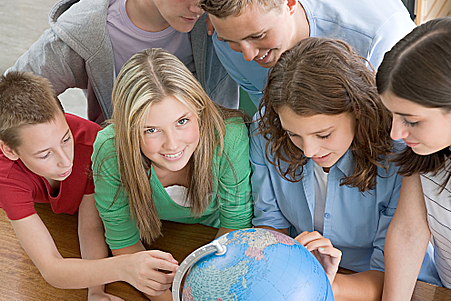 Group of children gathered around a globe