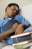Young man falling asleep holding books
