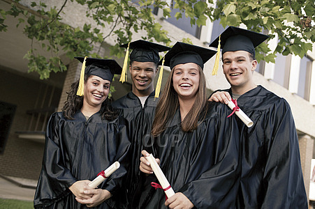 Four college students wearing graduation robes