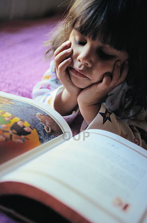 Six year old girl reading on the floor