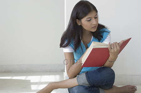 Asian girl sitting on the floor reading