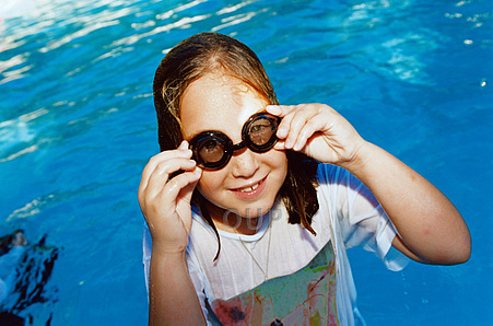 Girl in swimming pool with t-shirt and goggles