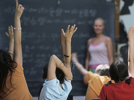 Children in class raising their hands