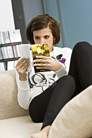 Teenage girl reading on couch