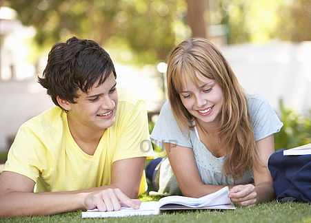 Students with a textbook in the park