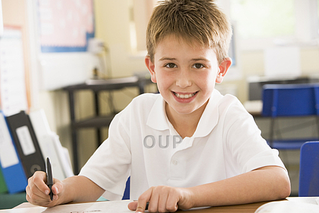 Young boy smiling and writing