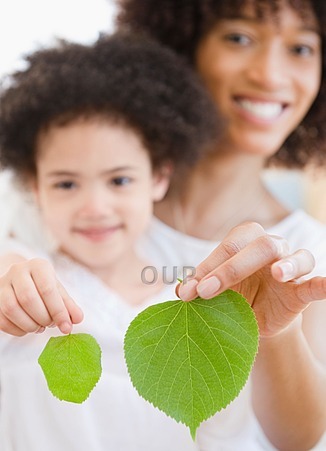 Mother and daughter holding leaves