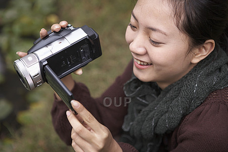 Asian woman using video camera