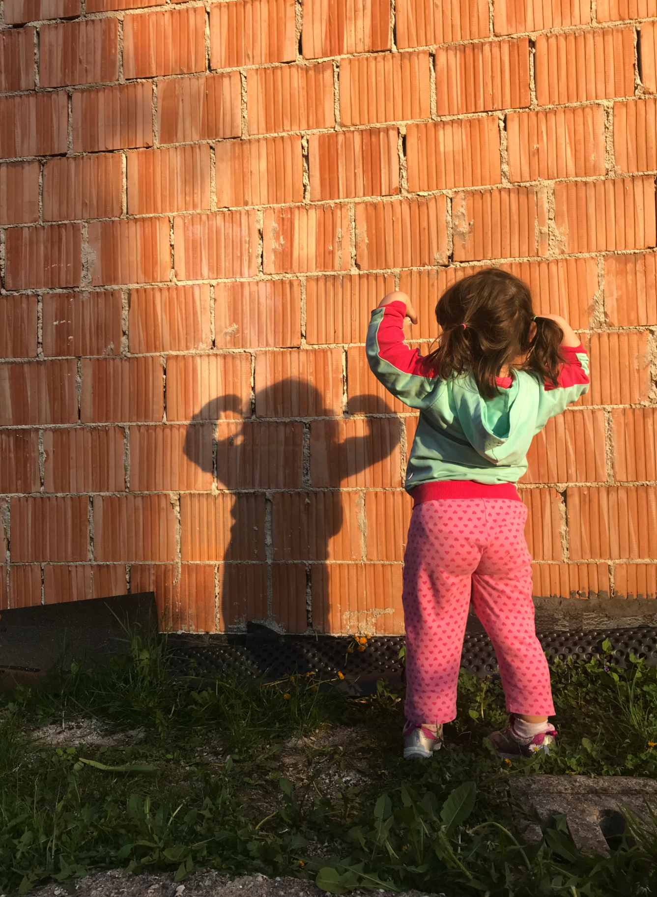 photographs: of a young girl making a pose and looking at her shadow on the wall